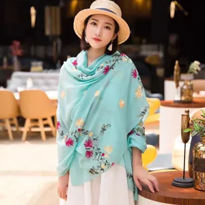 Detailed shot of ethnic style embroidered cotton linen scarf shawl, beautiful floral pattern design.