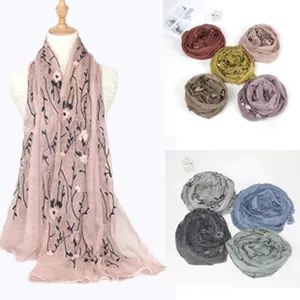 Detailed close-up view of bohemian embroidered linen scarf featuring delicate floral appliqués.