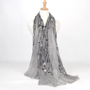 Grey embroidered cotton linen scarf detail showing delicate black vine and white flower patterns.