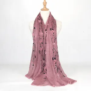 Detail view of the elegant cotton linen scarf featuring delicate floral embroidery and black branch design.