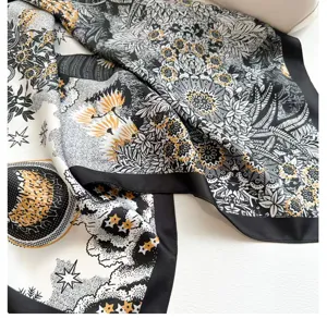 Gros plan détaillé du foulard en soie noir et blanc de luxe à motif floral et céleste.