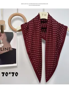 Detailed view of the elegant burgundy polka dot silk scarf, featuring soft fabric texture.