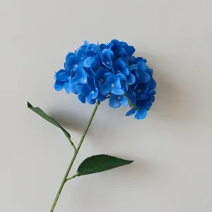 Detailed macro view of 3D printed blue artificial hydrangea petals and green leaf texture.