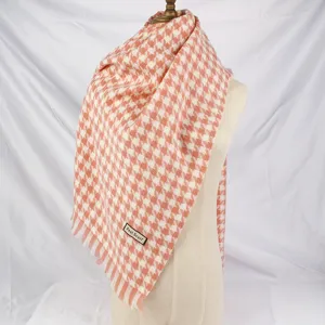 Close-up detail of the classic orange and white houndstooth pattern on this warm shawl