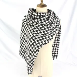 Detailed view of a classic black and white houndstooth thick shawl with tassel fringe