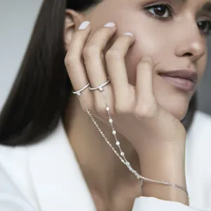 Close-up of 925 sterling silver hand chain bracelet with rings and zircon inlay