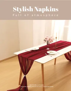 Close-up of a burgundy chiffon table runner with elegant drapes for wedding table decor