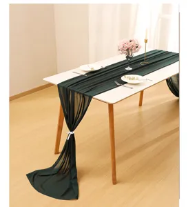 Detailed view of emerald green chiffon table runner draped on a white wedding table