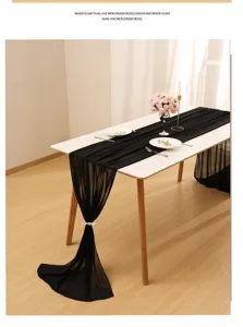 Elegant black chiffon table runner draped on a dining table for party and wedding decor.