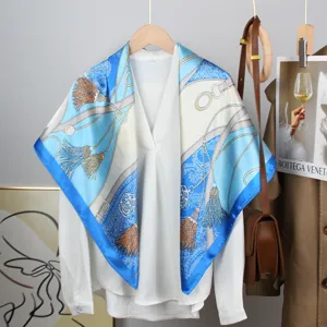 Elegant blue and white French vintage printed satin square scarf draped over a shirt.