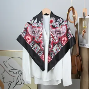 Elegant paisley print silk square scarf styled on a white blouse for a chic professional look.