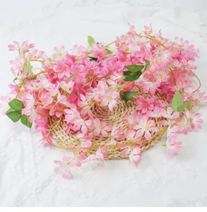 Close-up of pink artificial winter jasmine vine draped on a woven straw mat for decoration
