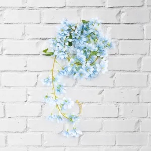 Light blue artificial jasmine flower vine waterfall decoration hanging on white brick wall