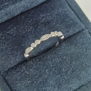 Gros plan d'une bague géométrique en argent S925 sertie de diamants étincelants.
