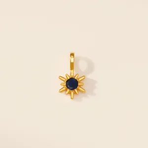 Détail du pendentif étoile à huit branches en acier titane doré avec gemme bleue.
