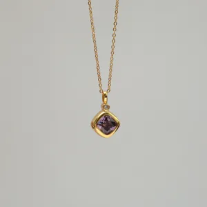 Detail of an 18K gold plated necklace featuring a square purple zirconia pendant