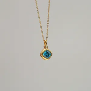 Detailed view of a gold-plated necklace featuring a vibrant square blue zircon pendant.