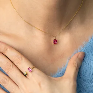 Gros plan d'un collier en or élégant avec pendentif en cristal rose sur le cou du mannequin