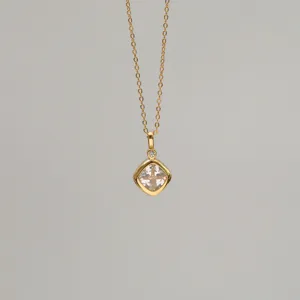 Close-up of a rhombus-shaped pendant necklace with clear zircon and gold plating.