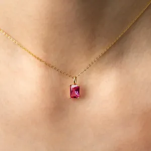 Gros plan détaillé d'un élégant collier en or avec un pendentif rectangulaire en pierre rose