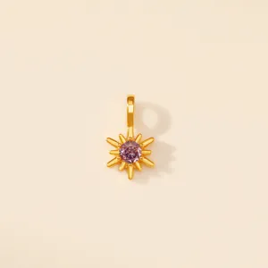 Détail d'un pendentif étoile à huit branches doré orné d'une pierre précieuse violette