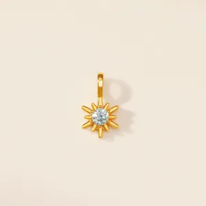 Vue détaillée d'un pendentif rayon de soleil doré avec une pierre précieuse centrale.
