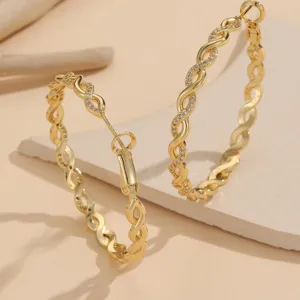 Detailed view of gold braided twist hoop earrings featuring sparkling micro-pave zirconia.