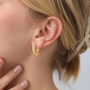 Detailed view of gold braided hoop earrings with micro-pave cubic zirconia accents