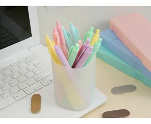 Detailed shot of macaron-colored retractable gel pens in a frosted desktop holder