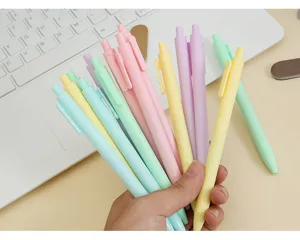 Hand holding colorful macaron pastel retractable gel pens for office stationery