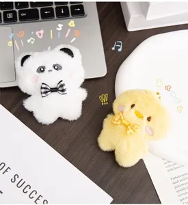 Detalle de primer plano de lindos llaveros de peluche de panda y pollito con lazos de cuadros