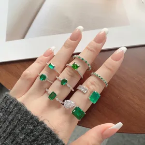 Primer plano de varios anillos vintage de plata con esmeraldas