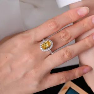 Anillo de lujo de plata S925 con diamante amarillo ovalado en la mano, detalle