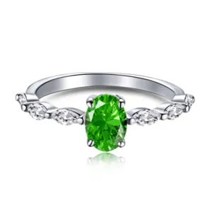 Vista detallada de anillo de plata con gema verde óvalo y acentos tipo marquise.