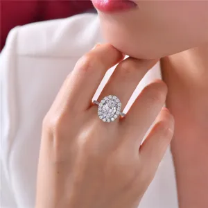 Primer plano exquisito de un elegante anillo halo ovalado con banda pavimentada