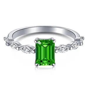 Vista macro detallada de un anillo con una gema verde esmeralda y diamantes marquise