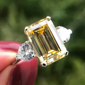 Primer plano de anillo de plata S925 con gemma amarilla talla esmeralda y corazones laterales