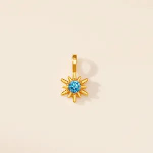 Vue rapprochée du pendentif étoile à huit branches avec gemme bleue en acier doré