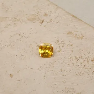 Macro view showing the brilliant facets of a yellow cushion-cut birthstone cubic zirconia gem