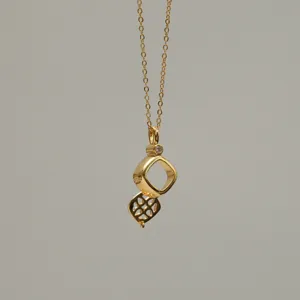 Detailed view of a detachable 18K gold plated necklace with geometric lattice pendant.