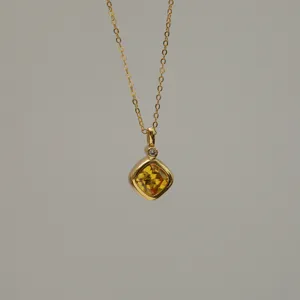 Close-up detail of a square yellow zircon pendant necklace with 18K gold plated finish
