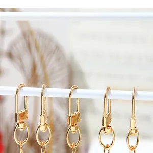 Detailed macro view of golden metal lobster clasps hanging for DIY keychain accessory making