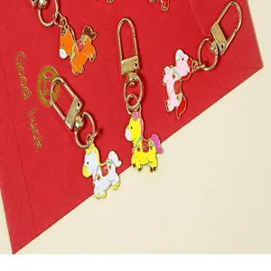 Detail view of cute colorful enamel zodiac horse keychains with golden metal clasp.