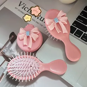 Cute pink bow-accented folding cushion hairbrush and massage comb set for travel