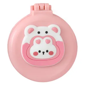 Portable folding hairbrush with mirror and cute cartoon bear design in pink.