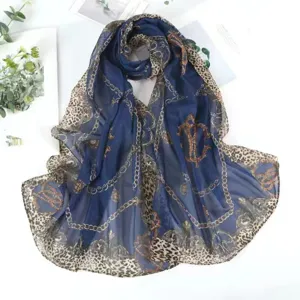 Dettaglio di sciarpa in chiffon blu navy con stampa leopardata e motivi a catena d'oro