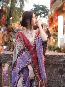 Detailed view of bohemian style multicolored knitted shawl wrap in a scenic outdoor setting