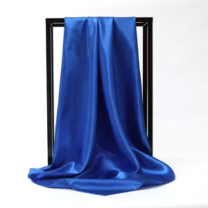 Close-up of a vibrant royal blue silk satin square scarf with smooth draping