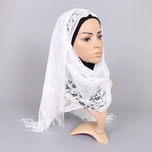 Detailed view of white hollow lace scarf with elegant tassel trim