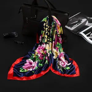 Close-up of elegant 90cm floral print satin silk square scarf draped on black bag